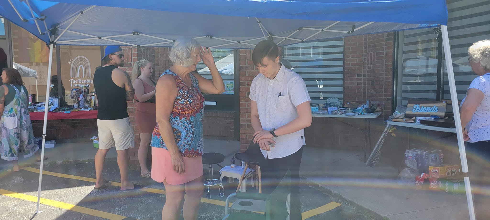 Linda watching Magician Wild Card perform a magic trick during the World Knitting Day parking lot party at Wrobel Massage Therapy.