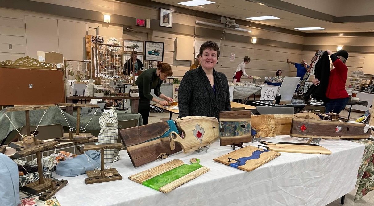 Trish Harris, owner of Kismet Woodworking, showcasing her handcrafted items on display and available for purchase at Wrobel Massage Therapy in Kingsville, Ontario.